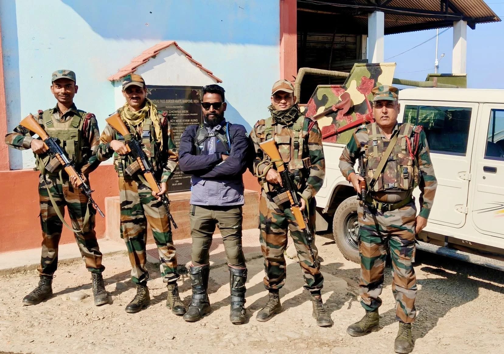 Motology rider standing with Indian Army personnel at a border post